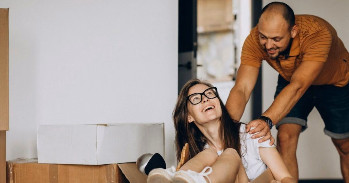 Een stel tussen verhuisdozen tijdens de verhuizing naar een nieuwe woning