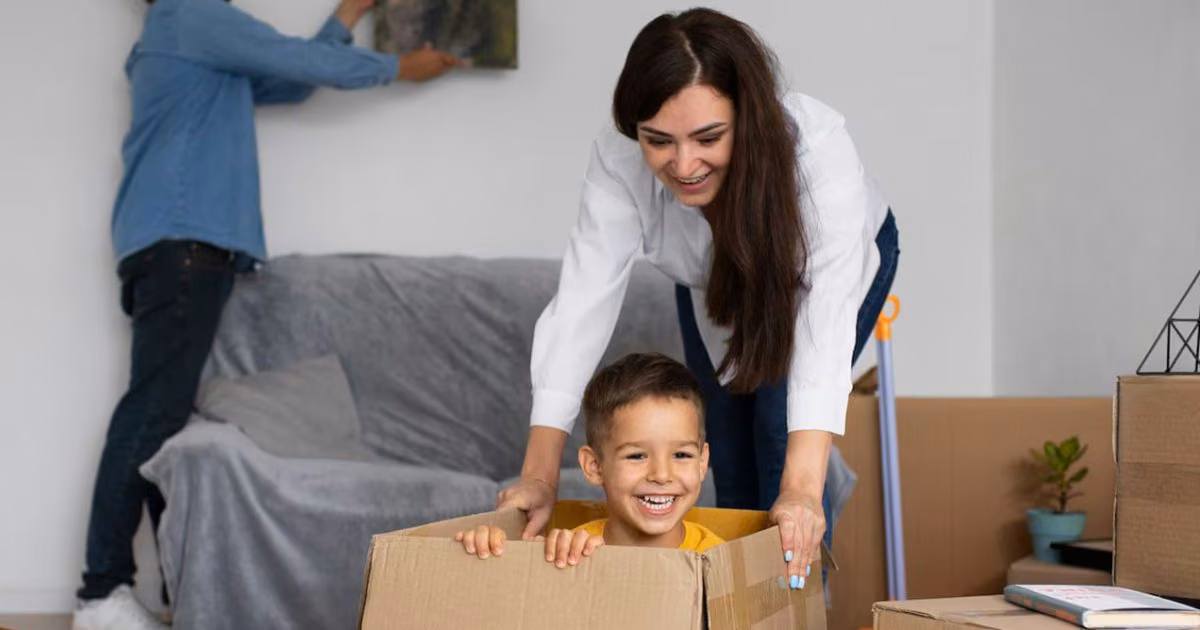 O familie împachetează cutii în timpul mutării într-o locuință nouă